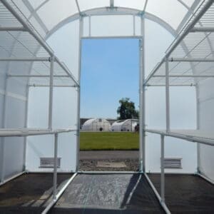 A view of a field through an open door.