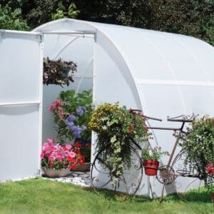 A bicycle parked in front of a greenhouse.